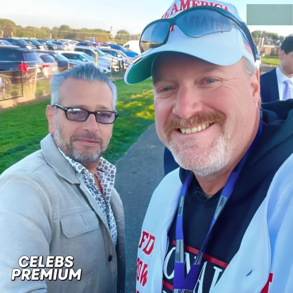 A photo of Scott LoBaido and his friend. Scott is on the left, wearing glasses and a light jacket. His friend is on the right, wearing a cap and a hoodie.